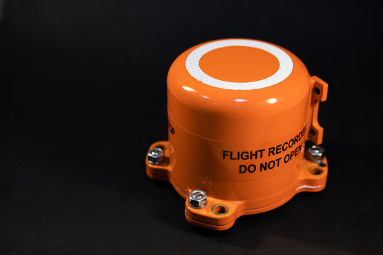 Aircraft flight data recorder on black background with free copy space. Black Box in orange-colored armored steel