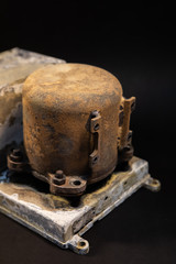 Damaged Aircraft flight data recorder on black background. Black Box with extensive fire damage after an accident or production testing of equipment