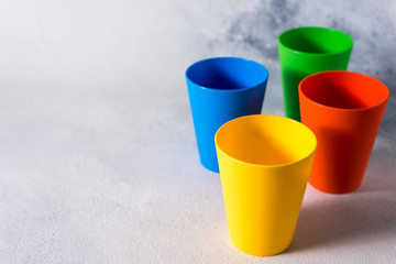 group color plastic cups on gray stone background plastic waste