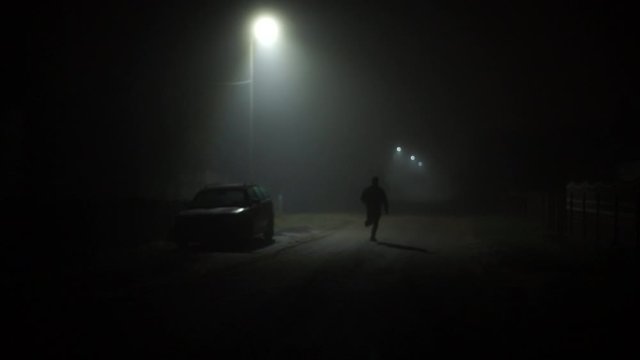 A man escapes from a criminal. Horrors. A man runs down a dark street. Kriminal.Mysticism. Night snapshot.