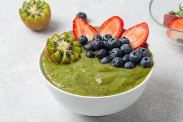 Detox Green Smoothie bowl from Matcha green tea, Banana, kiwi, blueberries and strawberries. Healthy breakfast