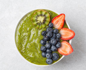 Detox Green Smoothie bowl from Matcha green tea, Banana, kiwi, blueberries and strawberries. Healthy breakfast