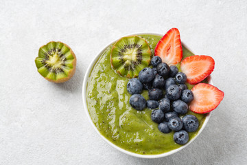 Detox Green Smoothie bowl from Matcha green tea, Banana, kiwi, blueberries and strawberries. Healthy breakfast
