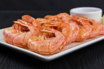 Fried shrimps with sauce and lemon on plate