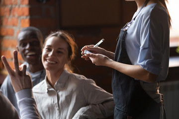 Close up of waitress take order from happy clients