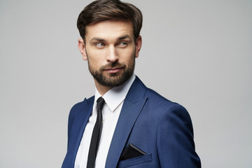 studio photo of young handsome stylish businessman wearing suit