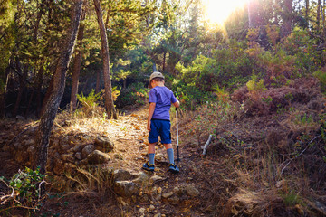 Young boy on his back walks through the forest exercising to relax and explore nature.