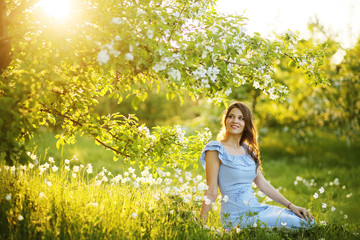 Fototapeta premium Girl at sunset in a flowering garden