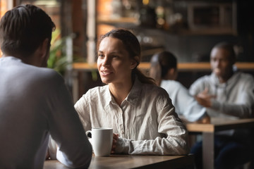 Millennial couple enjoy talking drinking coffee in cafe