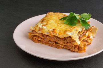 Meat lasagna on a wooden background.