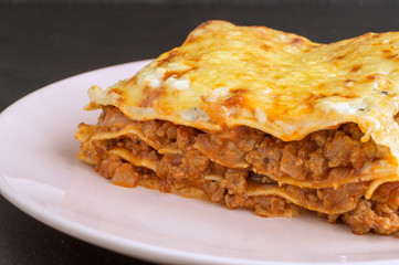 Meat lasagna on a wooden background.