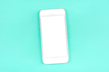 White smartphone on mint background. Flat lay. Space for your text.