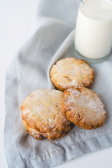 Stacked cookies on a linen napkin and a glass of milk. Close up.