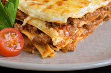 Meat lasagna on a wooden background.