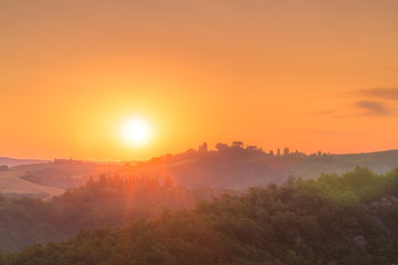 Fototapeta na wymiar Beautiful sunrise in the Tuscany hills with orange sky. Travel destination Tuscany