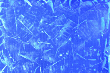 Abstract blue background close-up with brush strokes of white paint.