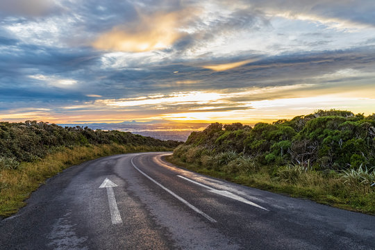 New Zealand, Clouds over empty asphalt road in Egmont National Park at dusk