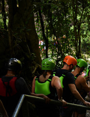 sportsmen in equipment go on a jump to a mountain river