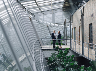 Businessman and businesswoman holding globe in modern office building