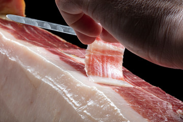 jamón iberico mano cortando con cuchillo. Iberian ham hand cutting with knife.