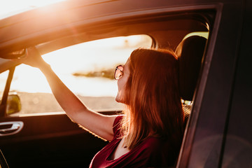 Fototapeta na wymiar young woman driving a car at sunset. travel concept