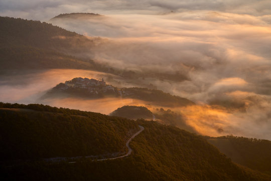 Italy, Aerial view of thick morning fog shrouding forested valley in Apennine Mountains