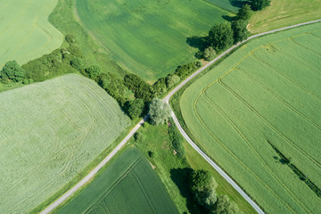 Germany, Bavaria, Aerial view of green countryside field and fork of empty road