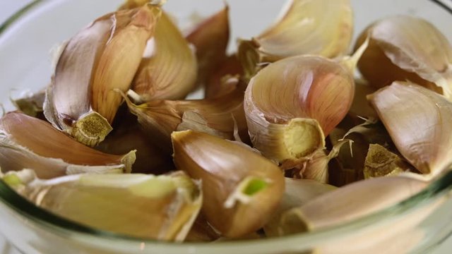 heads of garlic lie in a transparent bowl and spin