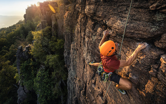Man climbing Battert rock during sunset