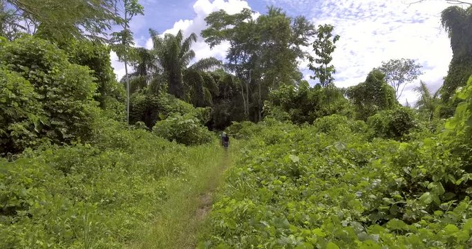 People Walking in a Dirty Road with many Vegetation Surrounded in a Clear Day in Pando / Bolivia 