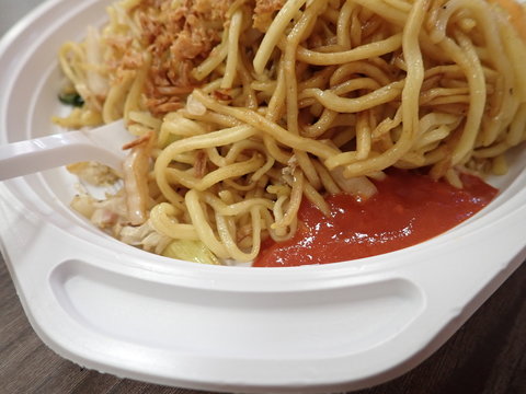  chinese noodles fire with vegetables on a plastic plate