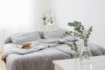 eucalyptus in glass vase in white bedroom