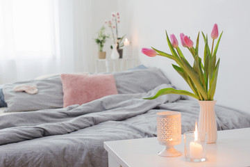 tulips in vase in cozy bedroom