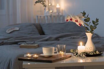 night interior of bedroom with flowers and burning candles