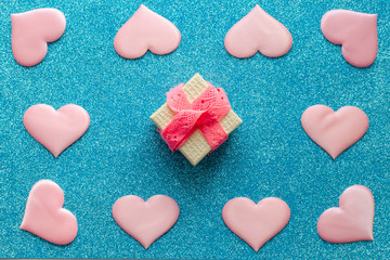Valentines day pattern background flat lay pink hearts and a pink gift box with rose ribbon on a glittering classic blue background with copy space. love wedding romantic concept, minimal top view