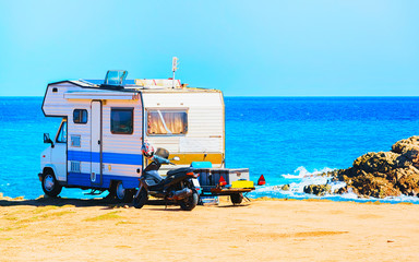 Camper and motorcycle on road at Capo Pecora at Mediterranean sea in Sardinia Island, Italy summer....