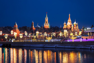 View of christmas Moscow, the Kremlin and Pokrovsky Cathedral, new year installations in the form of glowing trees and street lights in the form of champagne glasses, Russia
