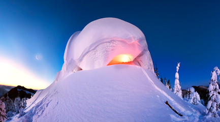 Snowy cornice on the mountain at night lamp