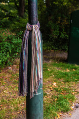 Colorful scarf tied to a lamppost in a park