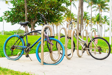 Fototapeta na wymiar Miami, Florida - December 30, 2019: Two Parked Bicycles One With a Flat Tire in Ocean Drive, Miami, Florida.