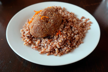 buckwheat porridge with a patty on a white plate served in a restaurant for lunch       