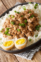Taiwanese pork minced meat with rice and eggs close-up in a bowl on the table. vertical
