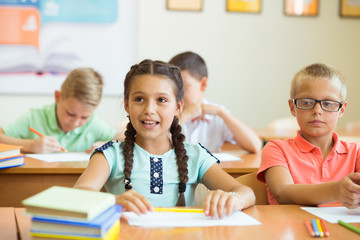 Cute schoolchildren study and answer questions in classroom during a lesson at primary school