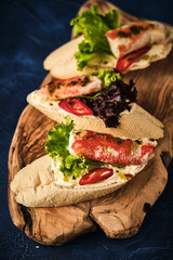 Bruschetta with butter, crab and chili on a wooden board.