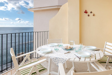 Appartamento bianco. Tavolo per la colazione sul terrazzo.