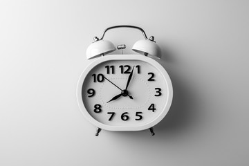 white alarm clock on white desk. - thinking and timing ideas concept.