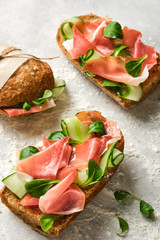 Italian sandwiches with bacon, cucumber and fresh herbs. Ciabatta with meat