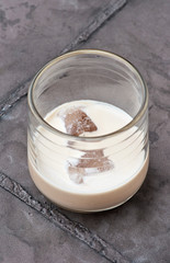 cream liqueur in glasses with ice on concrete background