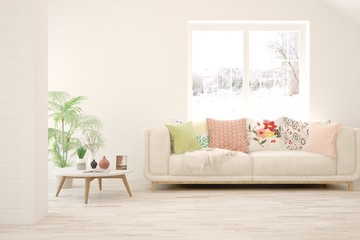 Fototapeta premium Stylish room in white color with sofa and winter landscape in window. Scandinavian interior design. 3D illustration