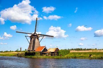 Naklejka premium Famous windmills in Kinderdijk village in Holland. Colorful spring rural landscape in Netherlands, Europe. UNESCO World Heritage and famous tourist site.